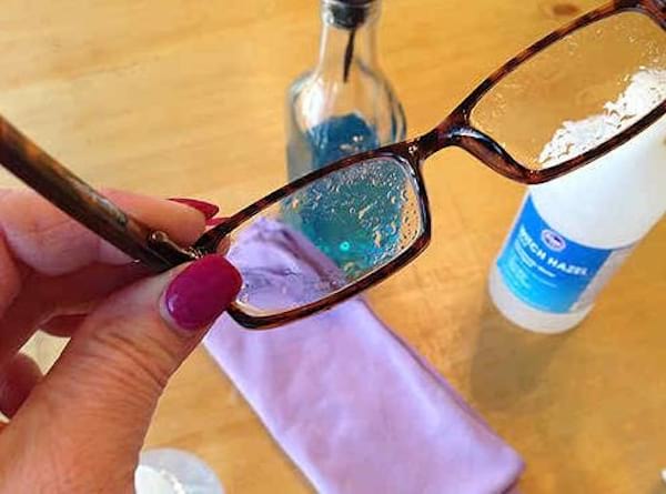 Des lunettes avec un spray nettoyant sur les verres.