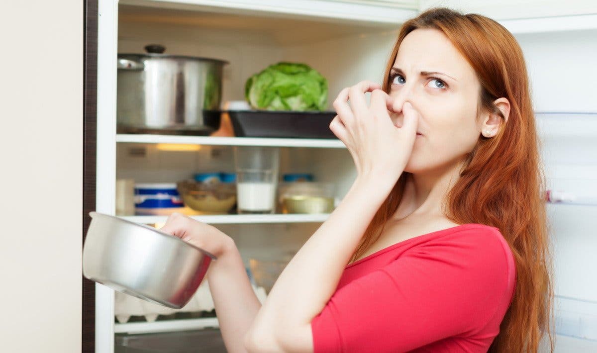 Une femme qui pense à nettoyer son réfrigérateur.